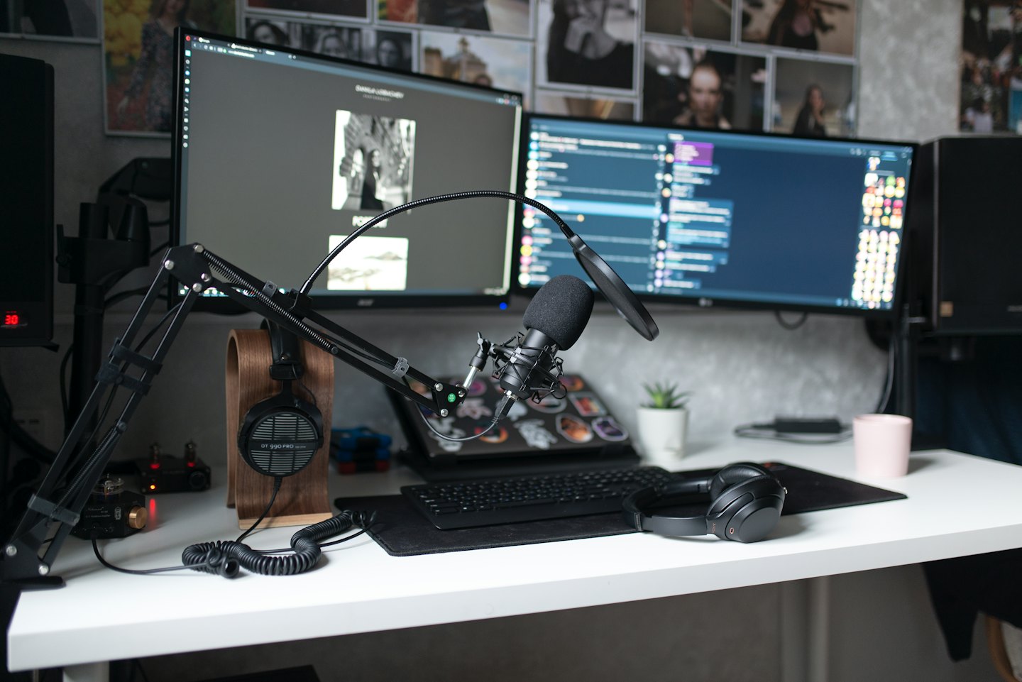 Schreibtisch mit zwei Monitoren, Mikrofon und Kopfhörern für die Content-Erstellung.